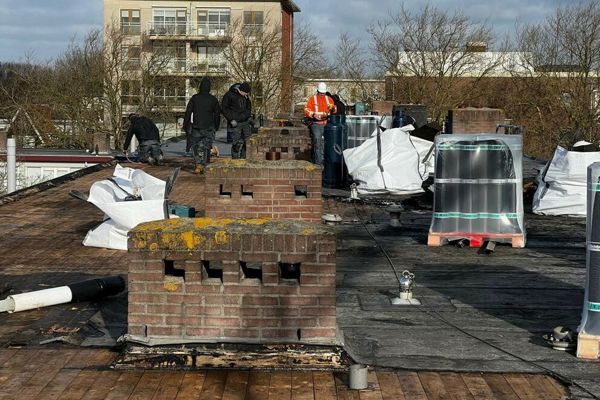 Diverse mannen werken op een dak