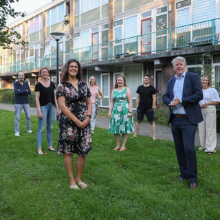 Groep mensen staat voor een woongebouw