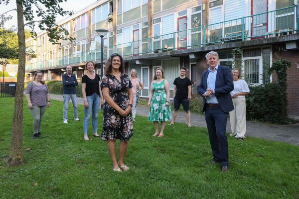 Groep mensen staat voor een woongebouw