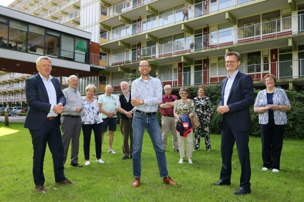 Groep met mensen staan voor een woongebouw