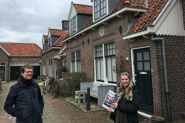 Twee medewerkers van Intermaris staan met het werken aan wonen boekje in de wijk