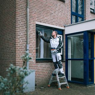 Schilder schildert het kozijn