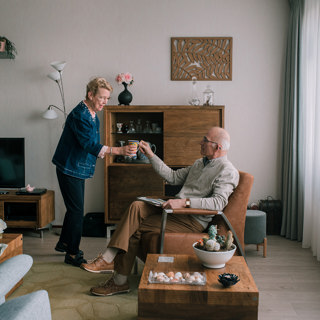 Bewoner geeft kopje koffie aan haar man