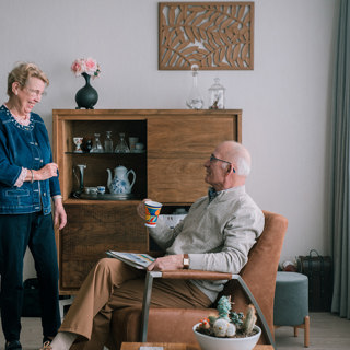 Bewoner geeft een kopje koffie aan haar man 