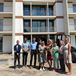 Directeur Cees Tip staat met bewoners voor een woongebouw