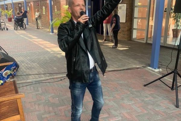 Zanger staat op straat in een microfoon te zingen