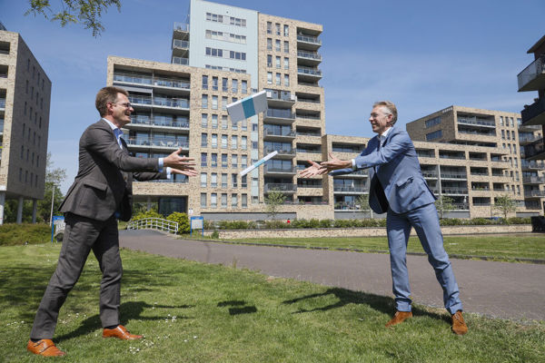 Twee mannen gooien pakketjes over naar elkaar