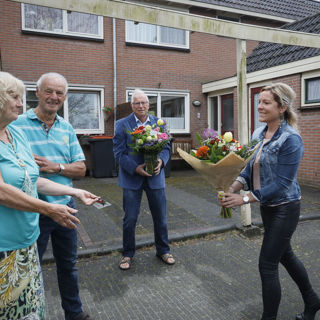 Bewoners krijgen bloemen van een medewerker van Intermaris