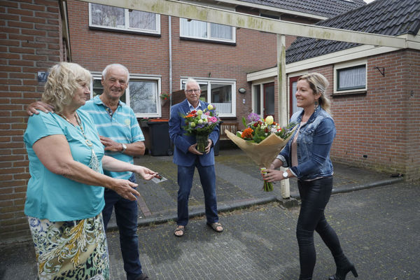 Bewoners krijgen bloemen van een medewerker van Intermaris
