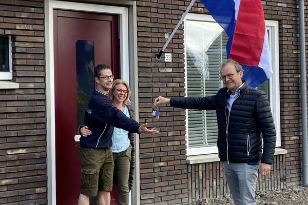 Bewoners ontvangen de sleutel van hun nieuwbouwwoning van een medewerker van Intermaris
