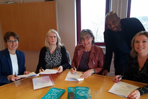 Diverse mensen ondertekenen een samenwerkingsovereenkomst