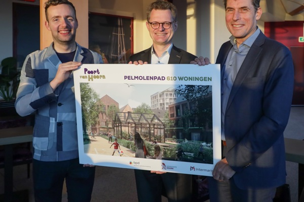 Drie bestuurders staan met een bord met nieuwbouwplannen in hun handen