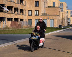 Medewerkers Intermaris fietsen met een bakfiets door de wijk