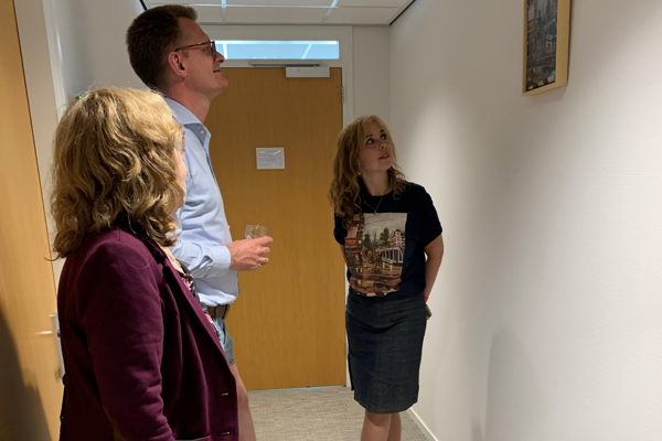 Kunstenaar Marcia bekijkt samen met Directeur Intermaris Cees Tip haar kunstwerk aan de muur