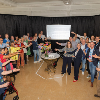 Diverse mensen reiken samen naar een bord met afspraken daarop