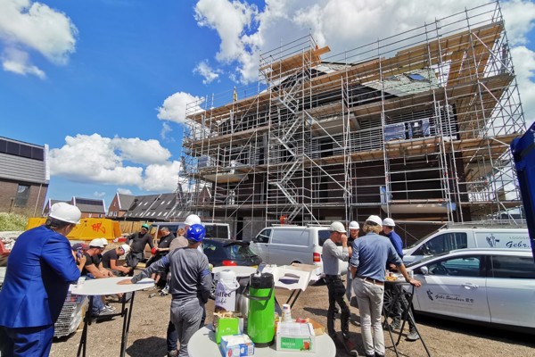 Woongebouw staat in de steigers, voor het gebouw staan bouwvakkers en medewerkers van Intermaris