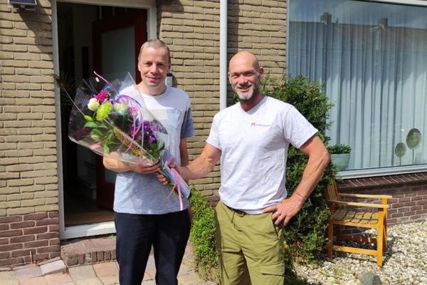 Bewoner krijgt bloemen van een medewerker van Intermaris