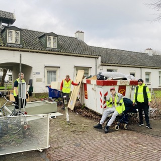 Waalhandjes staan bij een container met bouwafval voor het Truydemanshof