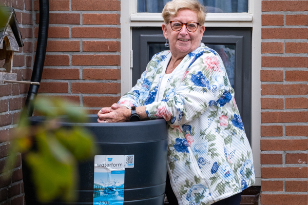 Bewoonster staat bij een regenton