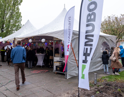 Partytenten en vlaggen bij de feestelijke opening van een woongebouw