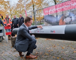 Directeur Cees Tip zet zijn handtekening op een leidingenbuis voor het warmtenet Kersenboogerd