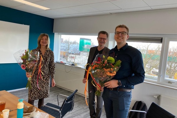 Nieuwe directeuren van Intermaris met een bosje bloemen