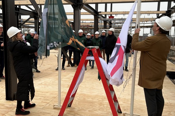 De vlag van Intermaris wordt gehesen bij een nieuwbouw project