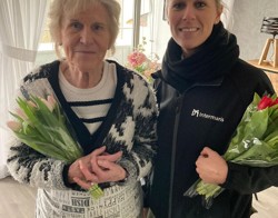 Bewoonster ontvangt een bos tulpen van medewerker Intermaris tijdens complimentendag