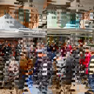 Verschillende bewoners zijn aanwezig bij de opening van een woongebouw 