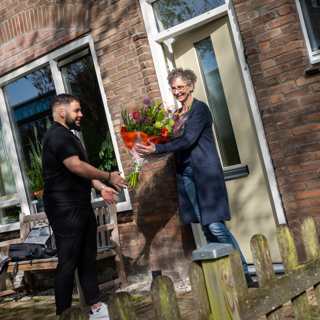 Bewoonster en medewerker Intermaris voor woning met bos bloemen