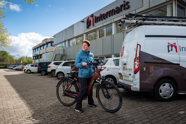 Medewerker Intermaris komt op de fiets aan bij het kantoor van Intermaris