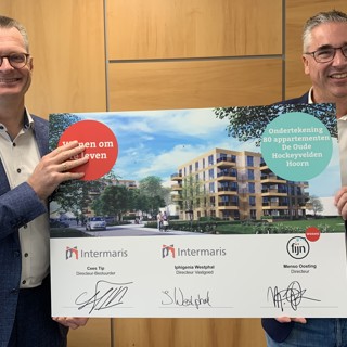 Directeur Fijn Wonen, Menso Oosting en directeur-bestuurder Intermaris, Cees Tip houden bord omhoog met handtekeningen De Oude Hockeyvelden