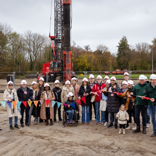 Genodigden en toekomstige bewoners houden vlaggenlijn vast op bouwlocatie Blok 14