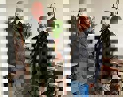 Bewoner heeft bos tulpen in handen en geeft medewerker Intermaris een hand