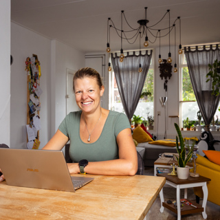 Bewoonster lachend achter laptop