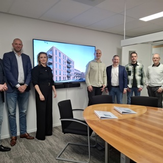 Acht medewerkers van Intermaris en Hoog Over staan voor televisiescherm impressie Henri Dunantstraat