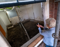 Vrouw kijkt naar werkzaamheden in het woongebouw